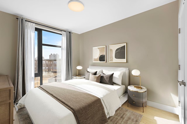 bedroom with light wood-style flooring and baseboards