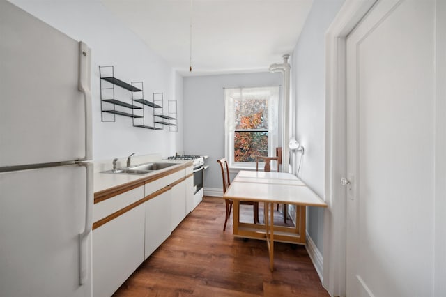 kitchen with white cabinetry, dark hardwood / wood-style flooring, white appliances, and sink