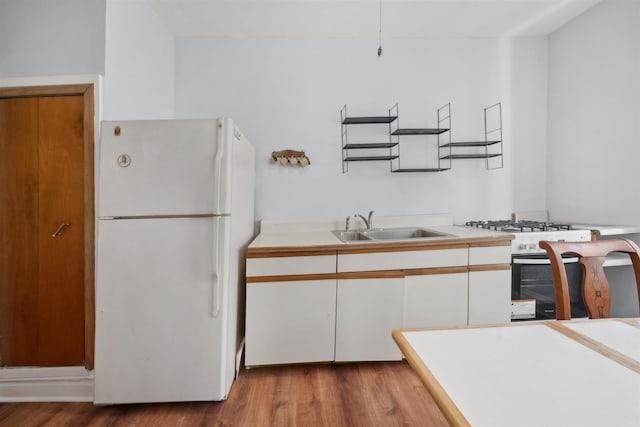 kitchen featuring white appliances, light hardwood / wood-style flooring, white cabinetry, and sink