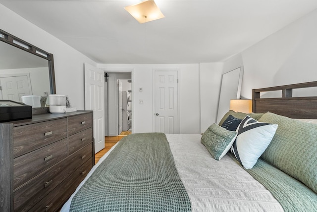 607 1st St Unit 1, Hoboken, NJ 07030 - bedroom featuring estacked washer and dryer and light wood finished floors