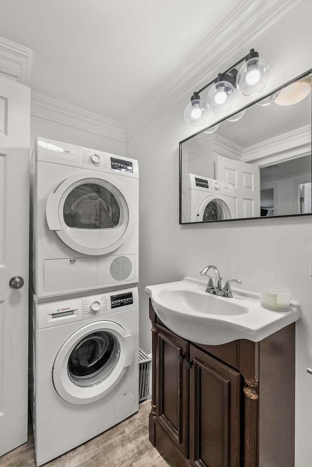 607 1st St Unit 1, Hoboken, NJ 07030 - laundry area featuring estacked washer and dryer, light wood-style flooring, and ornamental molding