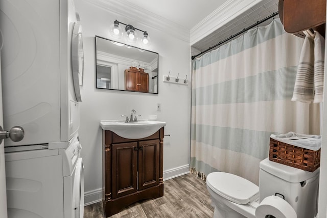 607 1st St Unit 1, Hoboken, NJ 07030 - bathroom featuring stacked washer / drying machine, wood finished floors, toilet, crown molding, and vanity