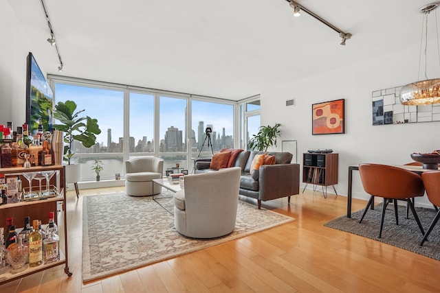 2 2nd St Unit 3103, Jersey City, NJ 07302 - living area featuring track lighting, hardwood / wood-style flooring, a skyline view, a chandelier, and a wall of windows