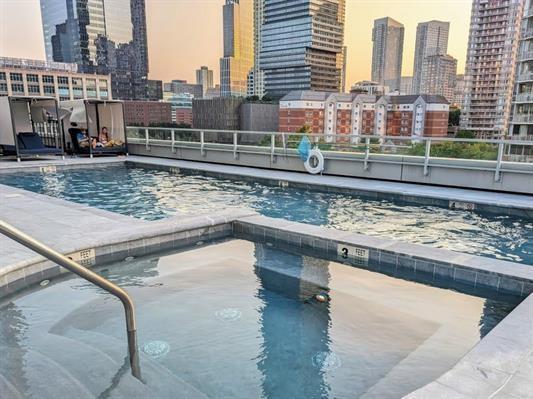 2 2nd St Unit 3103, Jersey City, NJ 07302 - pool at dusk with a skyline view, a community pool, and a hot tub