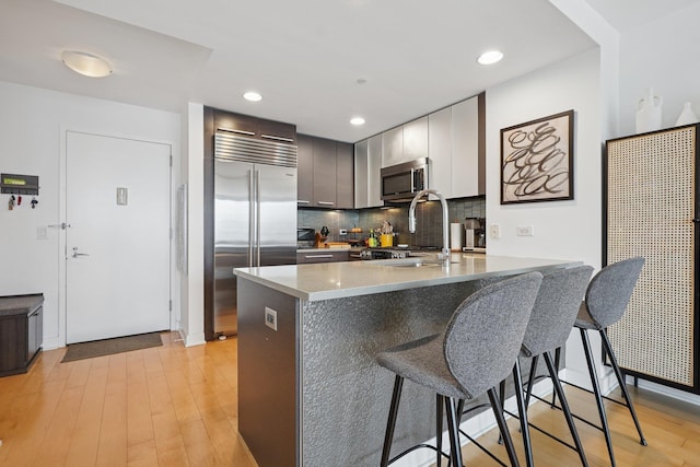 2 2nd St Unit 3103, Jersey City, NJ 07302 - kitchen with stainless steel appliances, a breakfast bar area, tasteful backsplash, a sink, and a peninsula