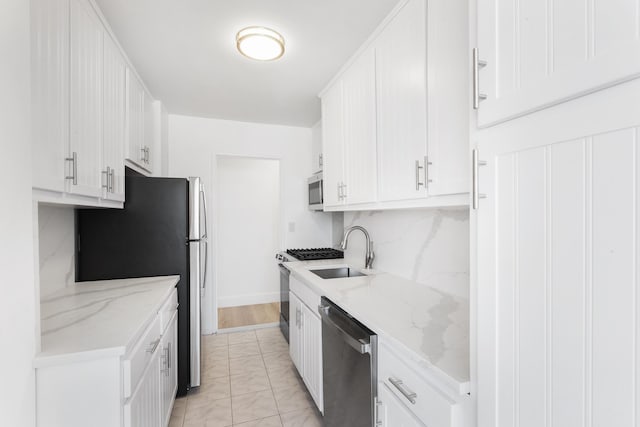 10 Huron Ave Unit 17F, Jersey City, NJ 07306 - kitchen with appliances with stainless steel finishes, a sink, white cabinetry, light marble finish flooring, and light stone countertops