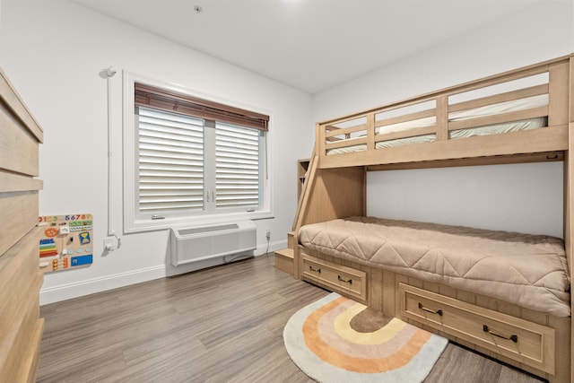 bedroom featuring a wall mounted air conditioner and hardwood / wood-style floors