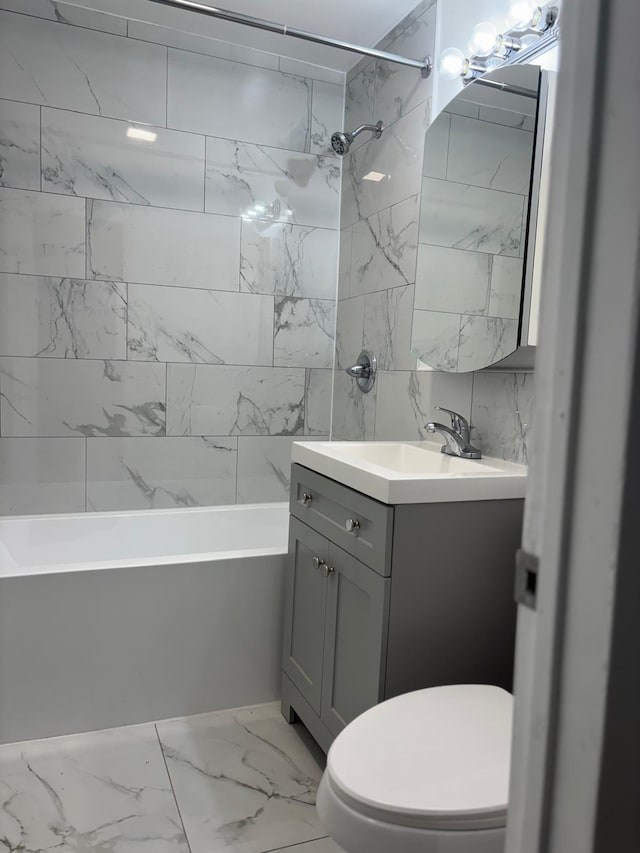 full bath with  shower combination, marble finish floor, toilet, and vanity