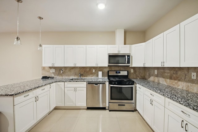 1160 Summit Ave Unit 2, Jersey City, NJ 07307 - kitchen with appliances with stainless steel finishes, tasteful backsplash, a peninsula, and white cabinets