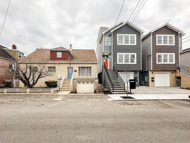 view of property featuring stairs, brick siding, and a garage