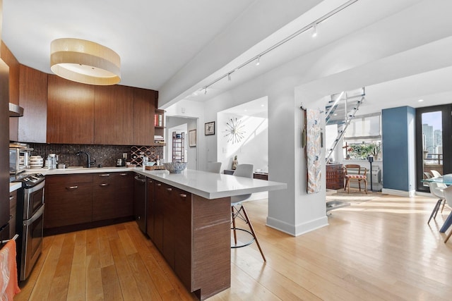 300 Newark St Unit 8G, Hoboken, NJ 07030 - kitchen featuring range with two ovens, a breakfast bar, track lighting, and light countertops