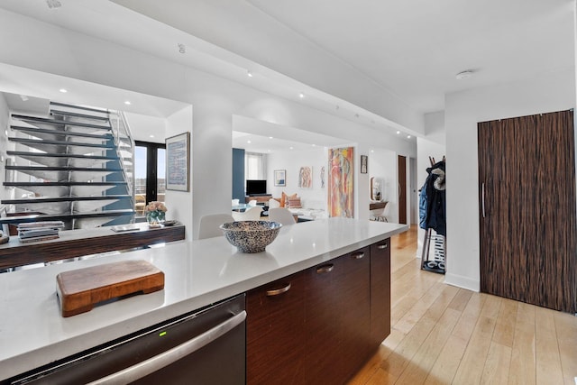 300 Newark St Unit 8G, Hoboken, NJ 07030 - kitchen with stainless steel dishwasher, light countertops, light wood-style flooring, dark brown cabinets, and modern cabinets