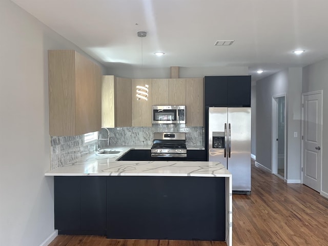 kitchen featuring dark hardwood / wood-style flooring, light stone counters, sink, light brown cabinets, and appliances with stainless steel finishes