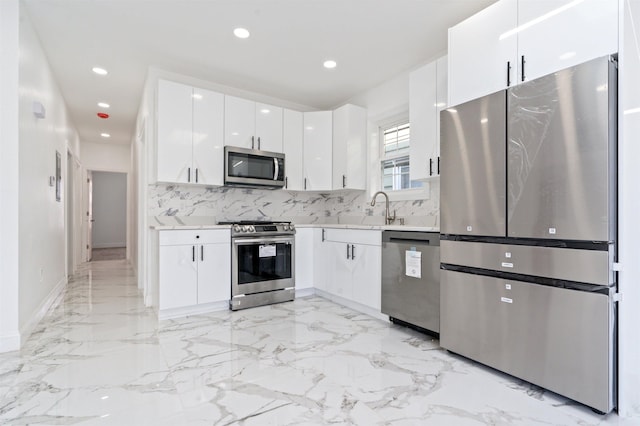 133 W 4th St, Bayonne, NJ 07002 - kitchen with appliances with stainless steel finishes, light countertops, tasteful backsplash, white cabinets, and light marble finish floors
