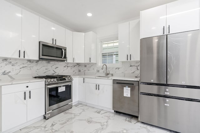 133 W 4th St, Bayonne, NJ 07002 - kitchen with appliances with stainless steel finishes, light countertops, white cabinetry, light marble finish flooring, and recessed lighting