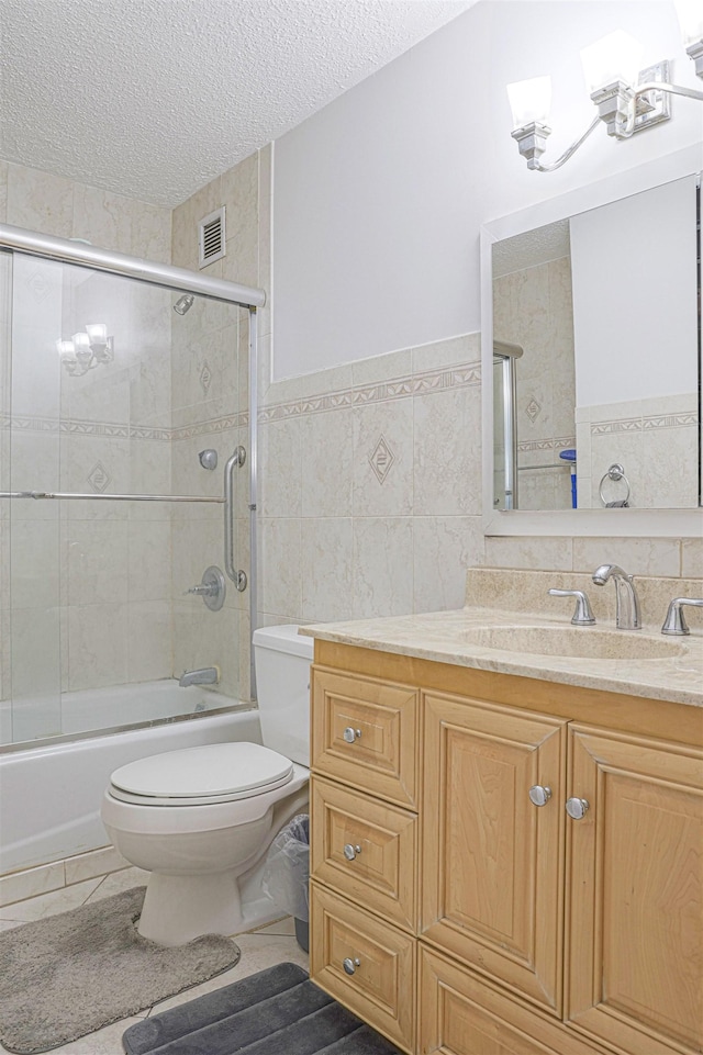 Harmon Cove Tower 426, Secaucus, NJ 07094 - full bathroom with tile walls, a textured ceiling, toilet, vanity, and enclosed tub / shower combo