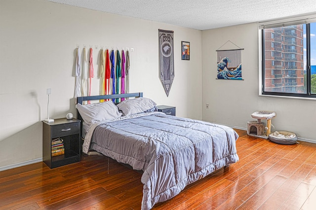 Harmon Cove Tower 426, Secaucus, NJ 07094 - bedroom with wood finished floors, a textured ceiling, and baseboards