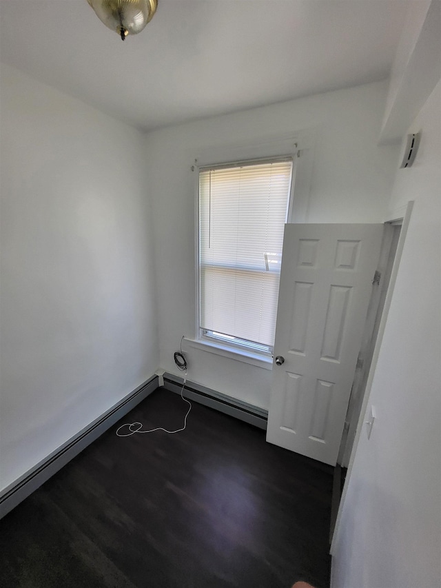 137 76th St, North Bergen, NJ 07047 - empty room with dark wood-style floors and baseboard heating