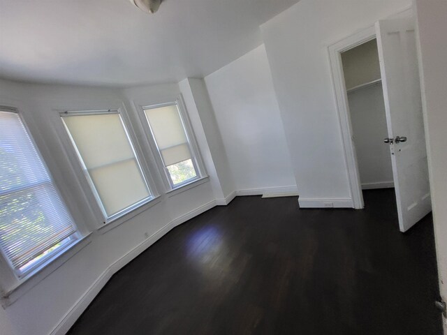 137 76th St, North Bergen, NJ 07047 - unfurnished bedroom with dark wood-style flooring and baseboards