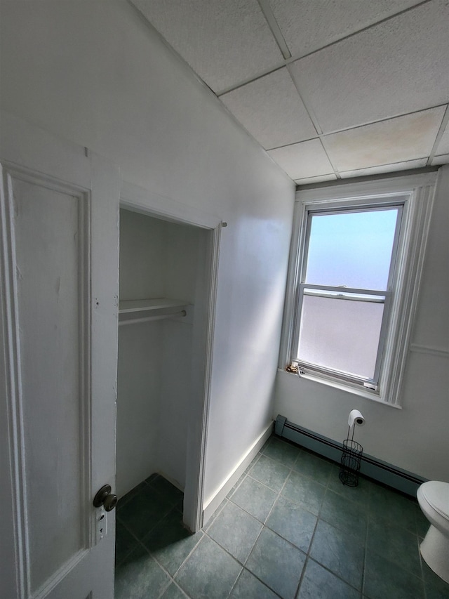 137 76th St, North Bergen, NJ 07047 - unfurnished bedroom featuring a baseboard heating unit, tile patterned floors, a drop ceiling, a closet, and baseboards