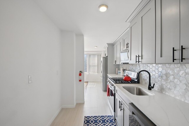 10 Huron Ave Unit 11D, Jersey City, NJ 07306 - kitchen with gas stove, tasteful backsplash, freestanding refrigerator, white microwave, and light stone counters