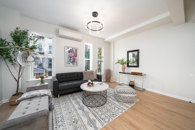 living room with a wall unit AC and light hardwood / wood-style flooring