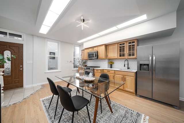 kitchen featuring tasteful backsplash, appliances with stainless steel finishes, sink, and light wood-type flooring