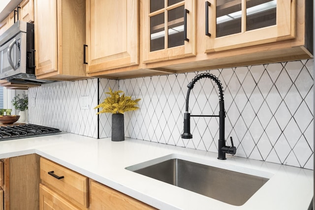 kitchen with light brown cabinetry, sink, and decorative backsplash