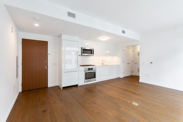 99 Hudson St Unit 601, Jersey City, NJ 07302 - kitchen with appliances with stainless steel finishes, a sink, white cabinetry, dark wood finished floors, and light countertops