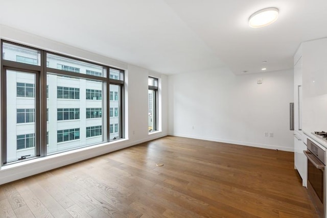 99 Hudson St Unit 601, Jersey City, NJ 07302 - unfurnished living room with wood finished floors, baseboards, and recessed lighting