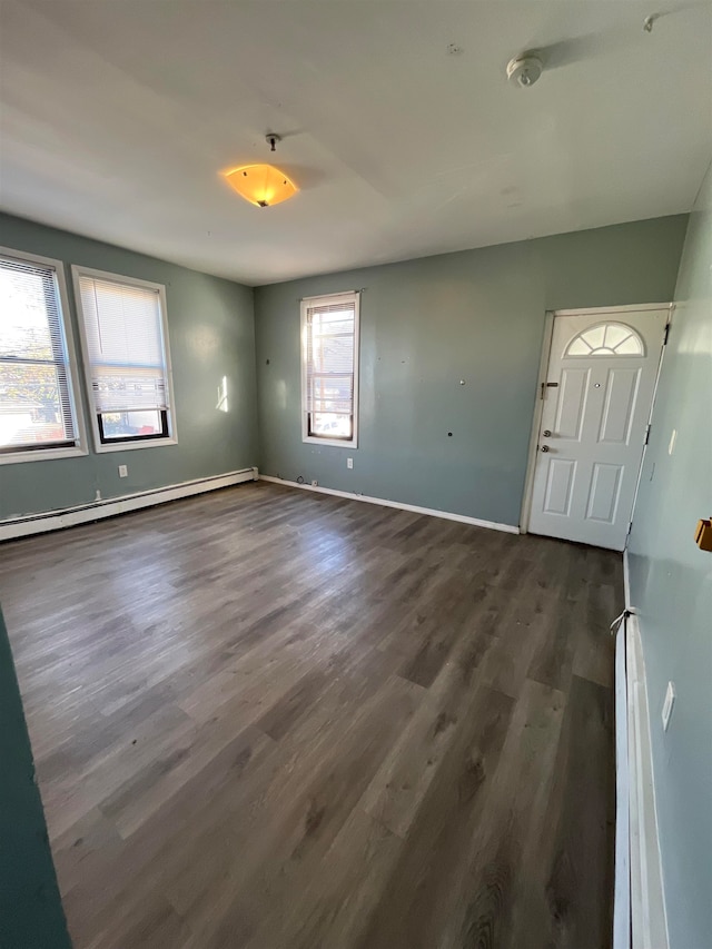 spare room with a baseboard radiator and dark hardwood / wood-style flooring