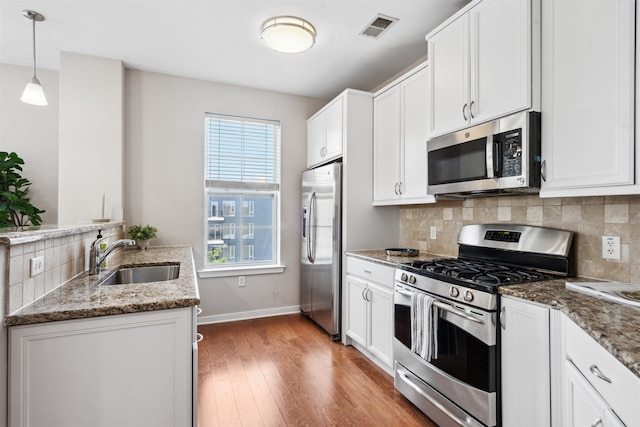 443 2nd St Unit 412, Jersey City, NJ 07302 - kitchen featuring appliances with stainless steel finishes, light wood-type flooring, stone countertops, and white cabinets