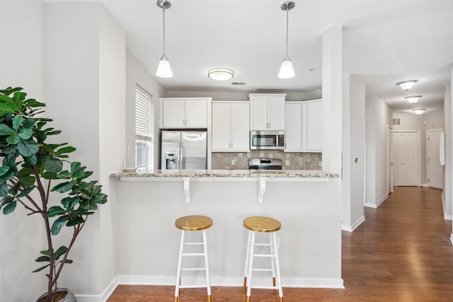 443 2nd St Unit 412, Jersey City, NJ 07302 - kitchen featuring appliances with stainless steel finishes, backsplash, a breakfast bar, light stone countertops, and dark wood-style floors