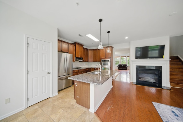 28 Creekside Ct Unit 28, Secaucus, NJ 07094 - kitchen featuring stainless steel appliances, a sink, light stone countertops, under cabinet range hood, and pendant lighting