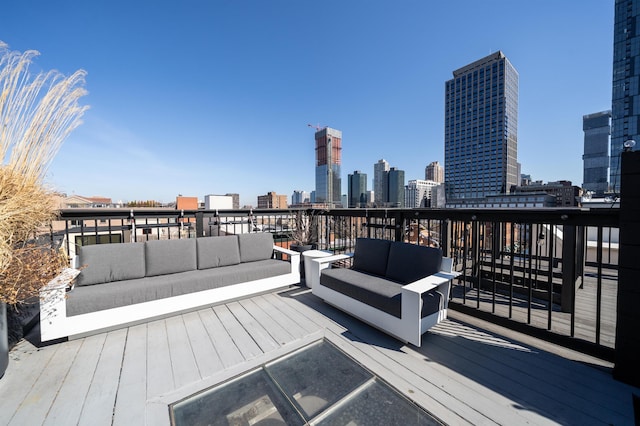 wooden deck with a view of city and outdoor lounge area