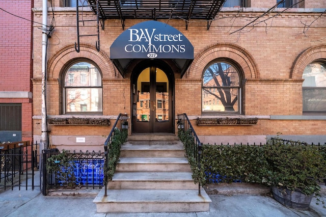 entrance to property featuring french doors and brick siding