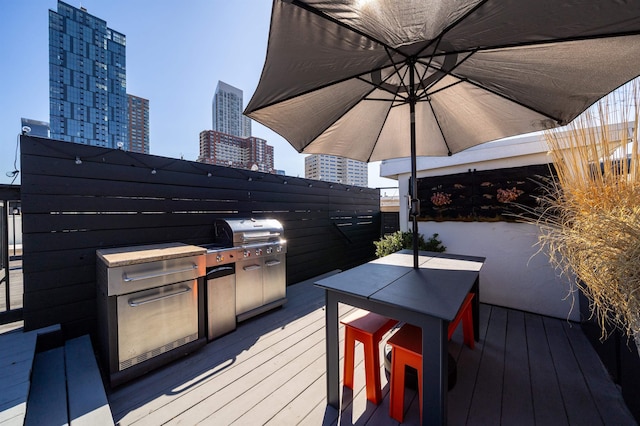 wooden terrace with a city view and grilling area