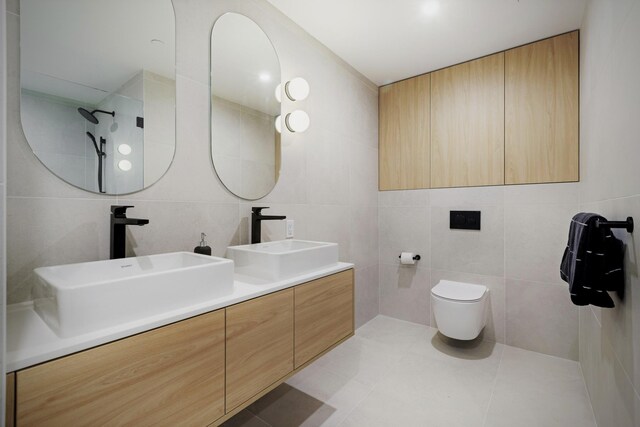 413 Monroe St Unit 200, Hoboken, NJ 07030 - bathroom featuring tile walls, double vanity, tile patterned flooring, and toilet