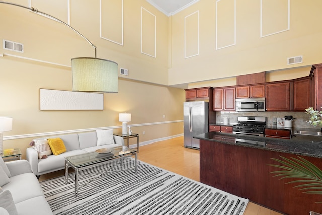 769 Montgomery St Unit 211, Jersey City, NJ 07306 - kitchen featuring appliances with stainless steel finishes, open floor plan, light wood-style floors, backsplash, and a peninsula