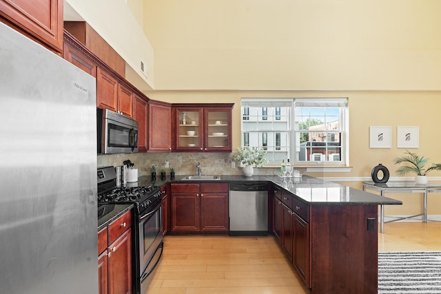 769 Montgomery St Unit 211, Jersey City, NJ 07306 - kitchen featuring appliances with stainless steel finishes, reddish brown cabinets, and light wood-style floors