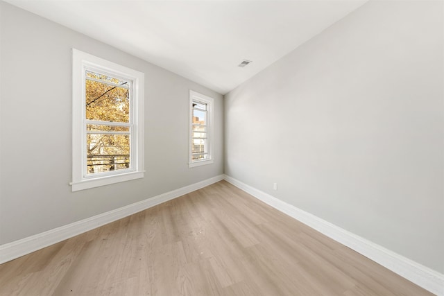 spare room with lofted ceiling and light hardwood / wood-style floors