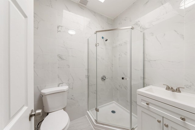 bathroom featuring toilet, vanity, tile walls, and a shower with shower door