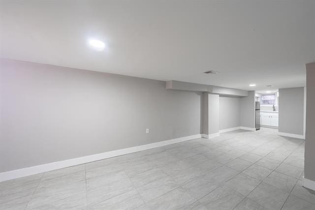 basement with stainless steel refrigerator