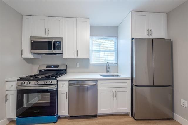 kitchen featuring white cabinets, appliances with stainless steel finishes, and sink