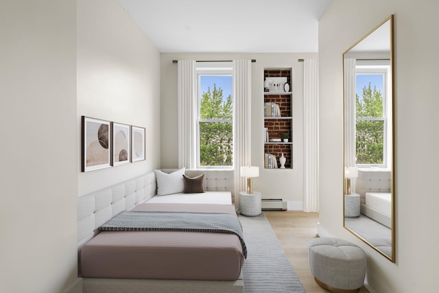 bedroom featuring baseboard heating and wood finished floors