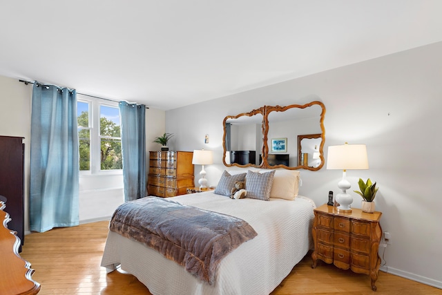 bedroom with baseboards and light wood-style flooring