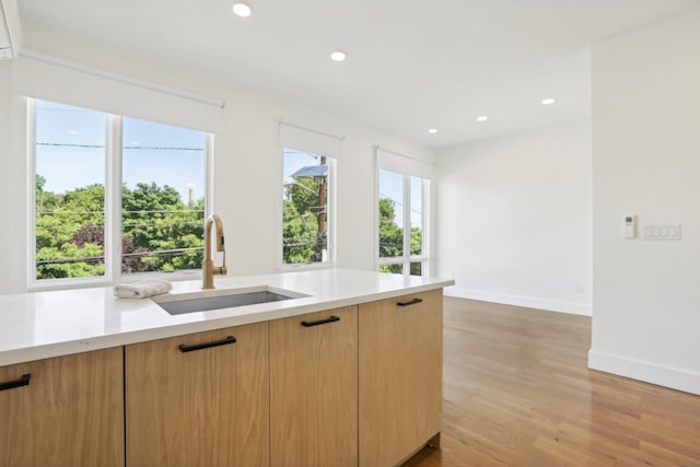 kitchen featuring light brown cabinetry, light hardwood / wood-style flooring, and sink