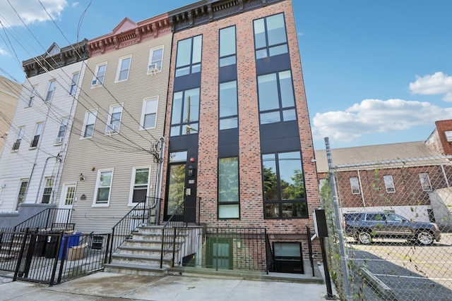 view of front facade with fence and brick siding