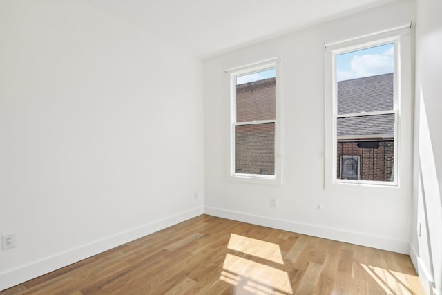 spare room with light wood finished floors and baseboards