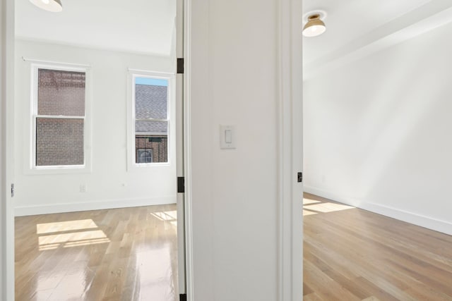 hall featuring baseboards and wood finished floors